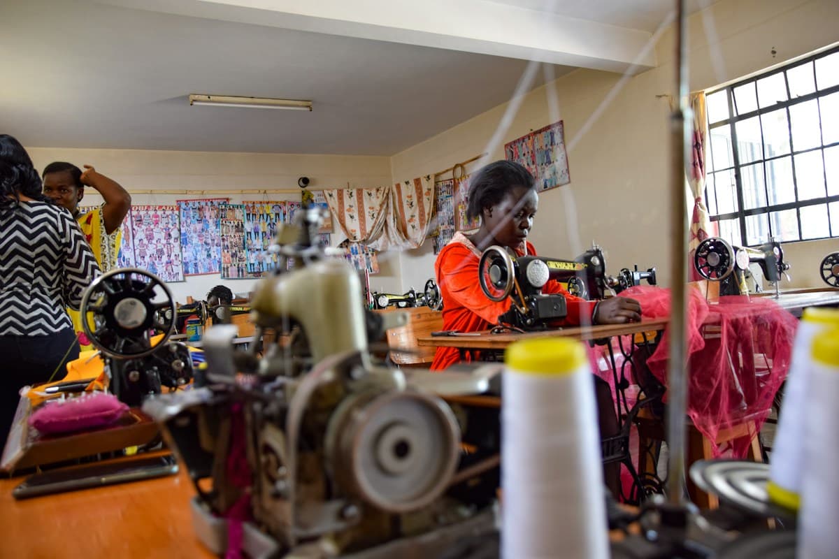 Women learning and working at sewing machines at Kivuli Tailoring School in Nairobi, Kenya